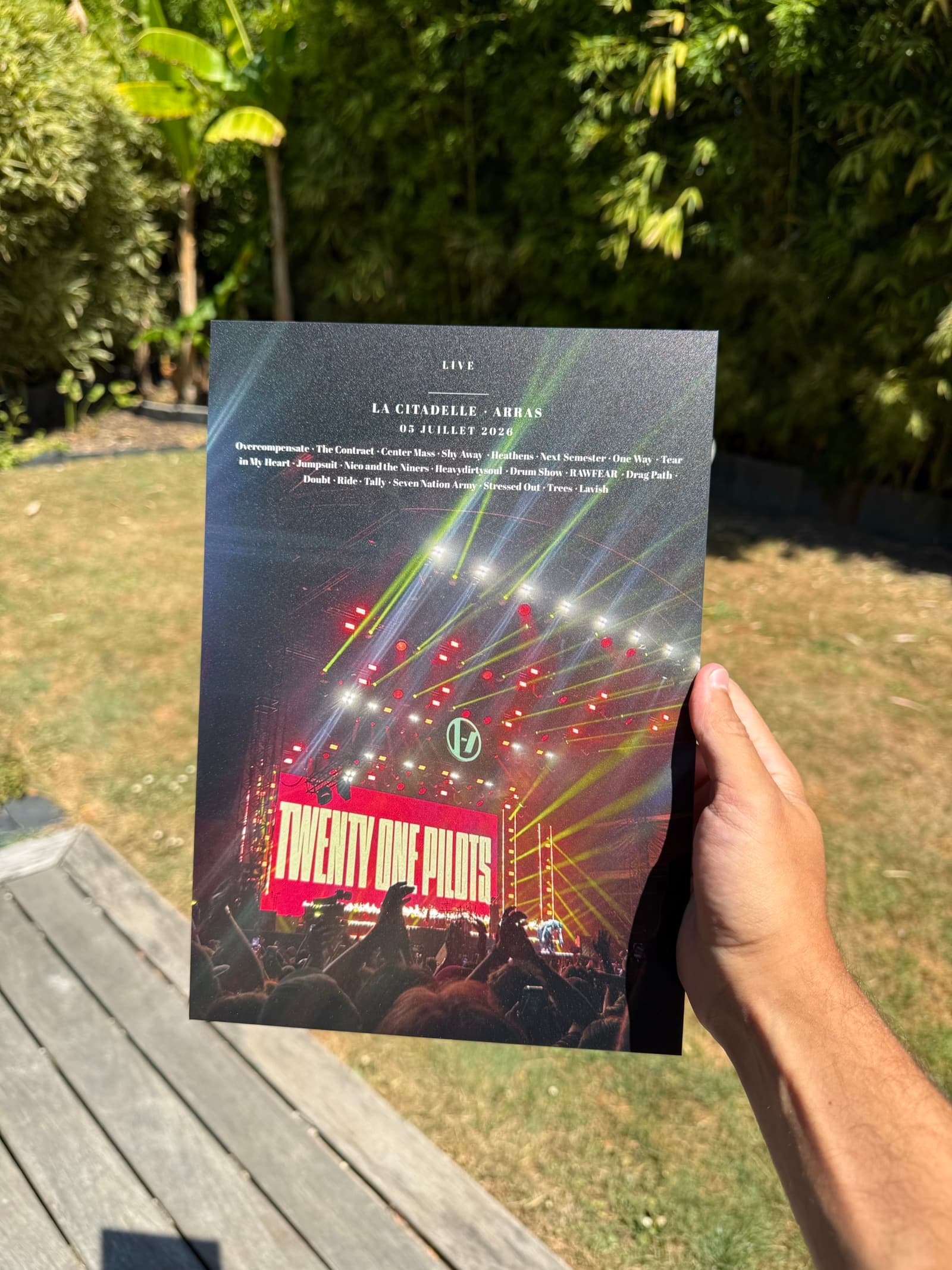 Print de concert sur Dibond tenu d'une main en extérieur